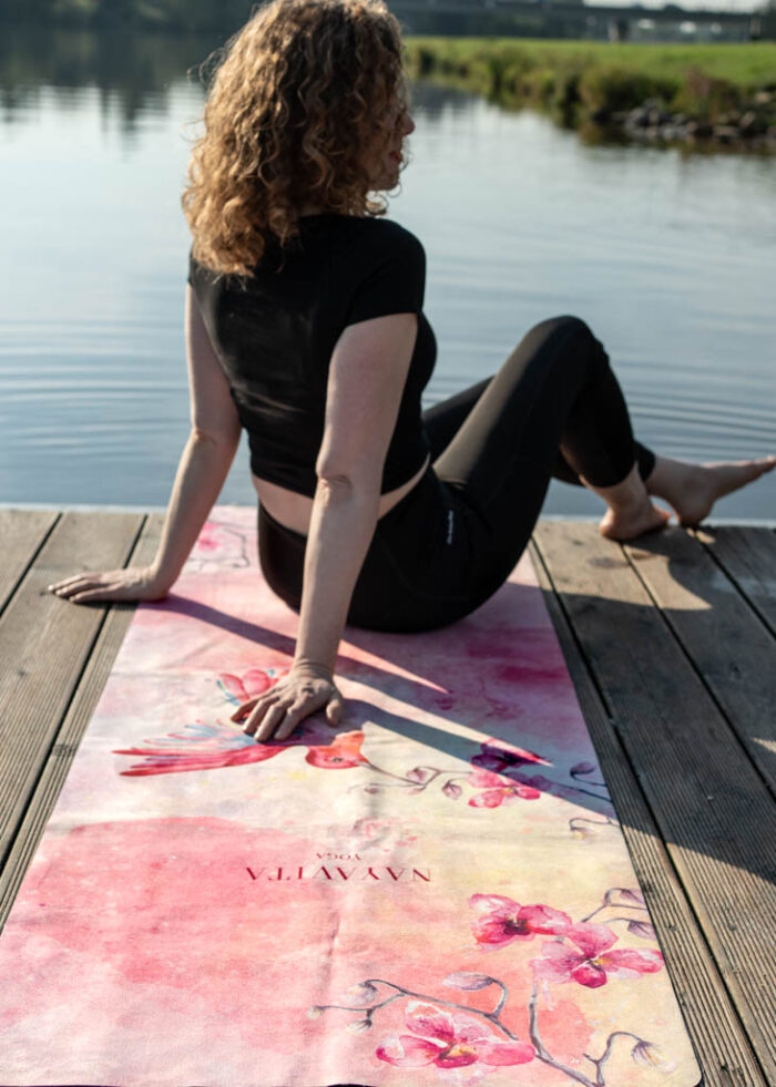 Žena cvičí klidnou jógu na měkké jógové podložce na doma Colibri Dream s pastelovým designem kolibříka od NAYAVITA Yoga
