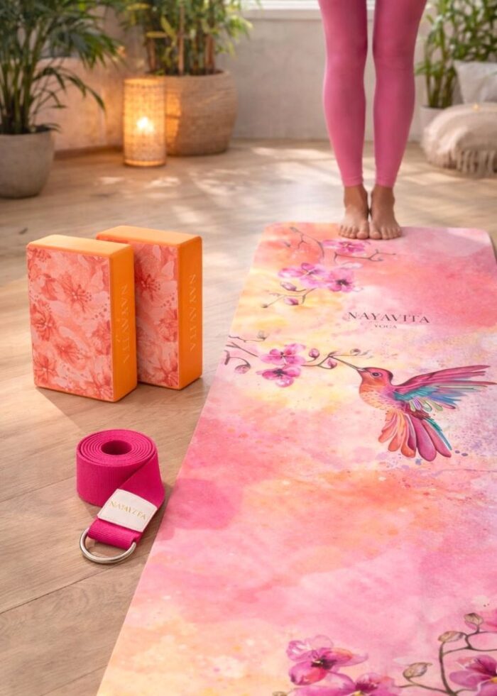set na cvičení pro aktivní ženy Colibri Dream s oranžovými bloky na jógu Sakura, růžovým popruhem a podložkou s kolibříkem Colibri Dream v interiéru při dynamickém domácím cvičení